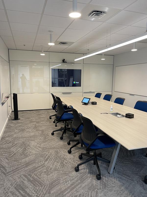 Glass-walled boardroom with the table cleared and set