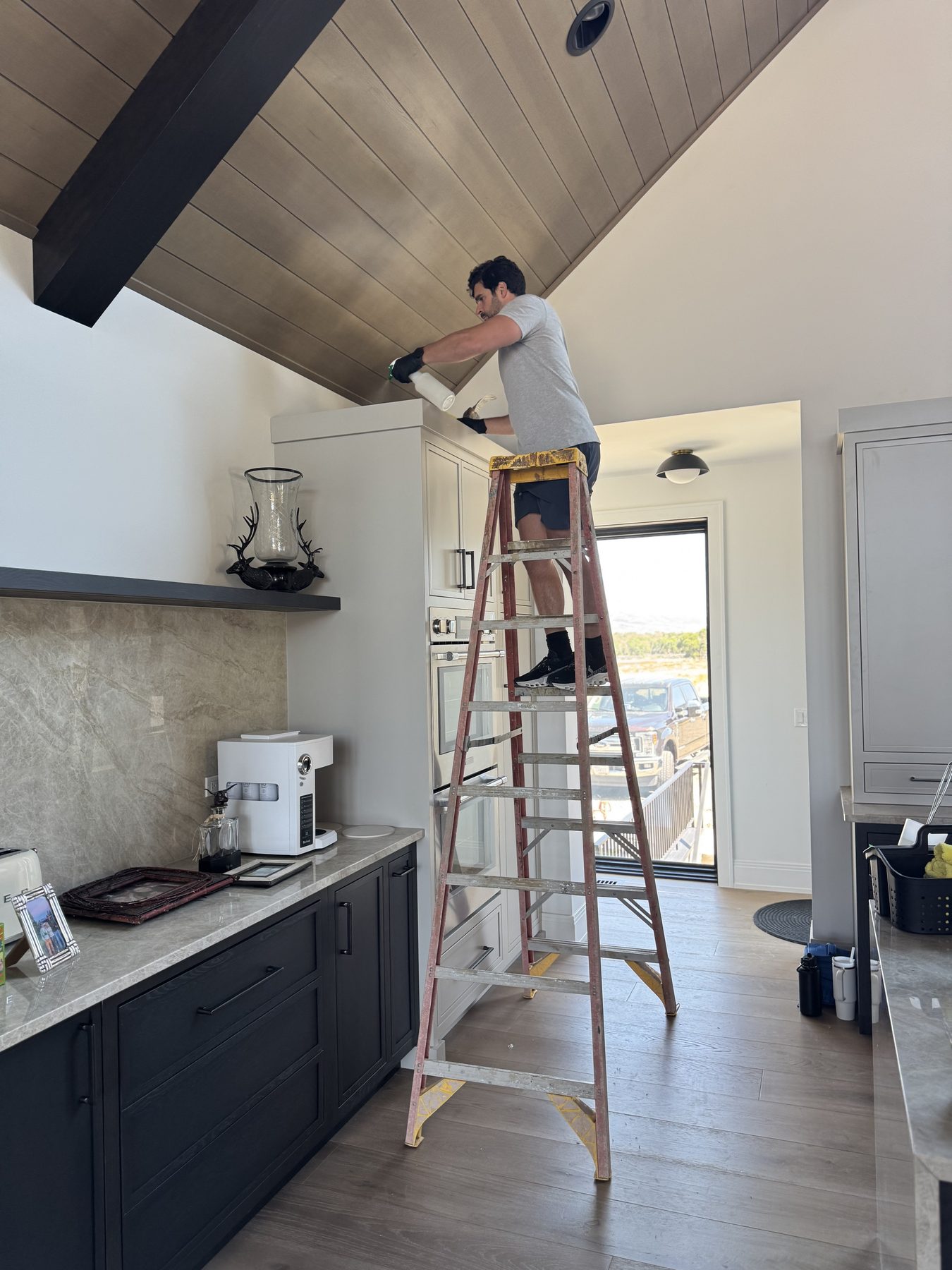 A team member on a ladder detailing a high surface